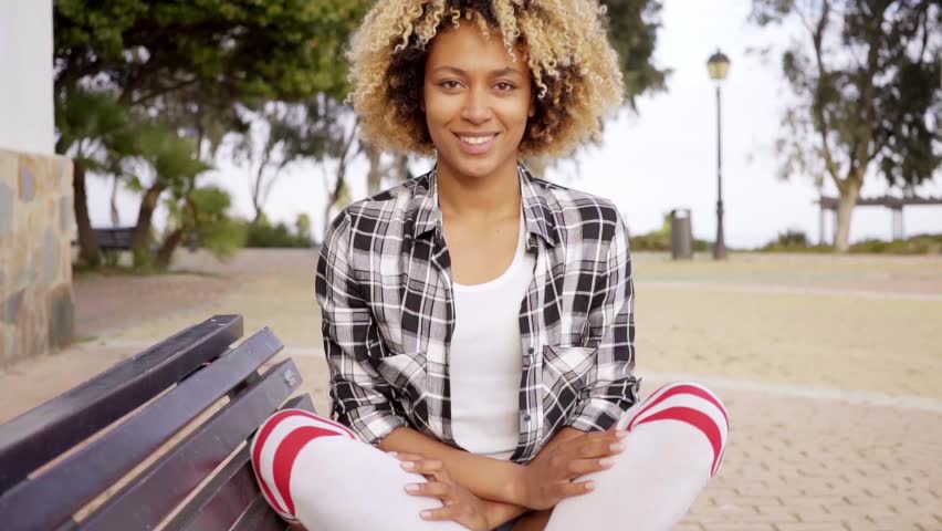 Young woman with crossed legs on bench