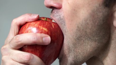 Closeup of a unshaven man eating an apple