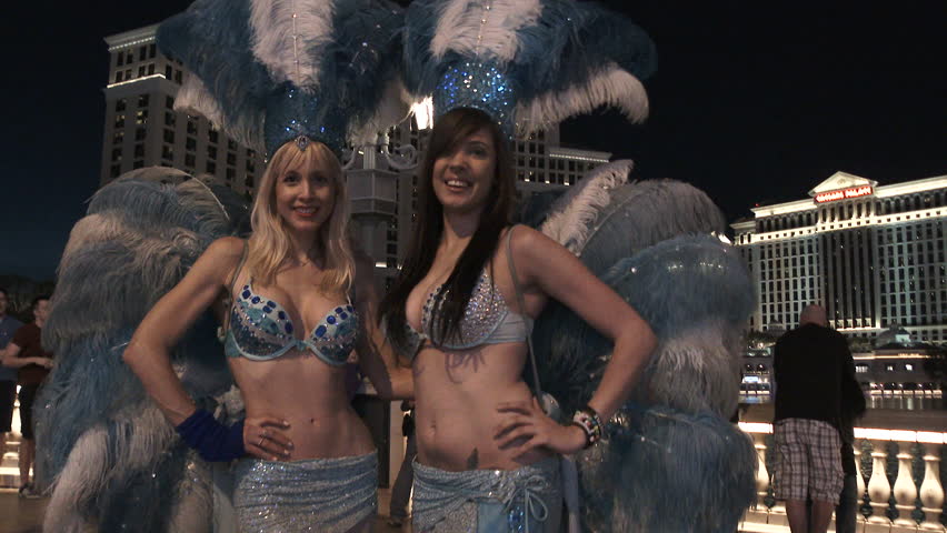 LAS VEGAS, NEVADA - CIRCA 2016: Two showgirls out front of the Bellagio Hotel and Casino at night welcoming you to Las Vegas, Nevada and the strip.