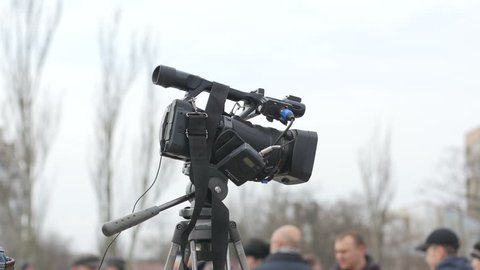 KHERSON, UKRAINE - MAR 12, 2016: A public celebration of Shrovetide carnival - Cameraman shooting video for news via professional camcorder on a public place