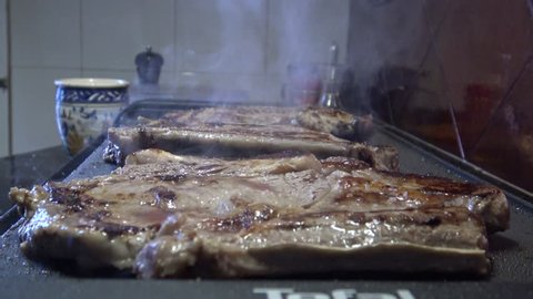 4k, cheff is cooking a Steak in hot Griddle of a kichen, T-bone steak is low fat healthy living meal choice -Dan