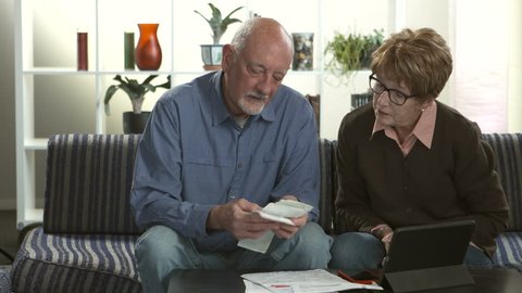 A senior couple stressed over paying bills