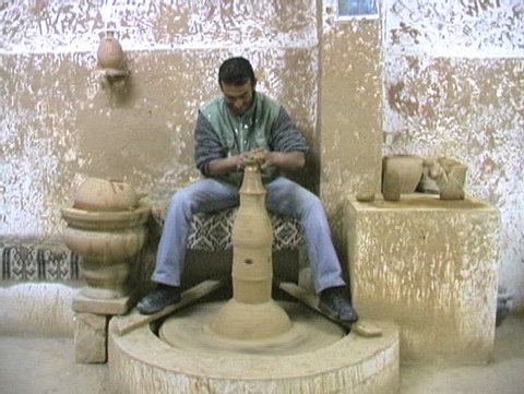 Using the old fashtion way to make ceramic pottery.  Worker uses his leg to turn the wheel to make the sugar bowl