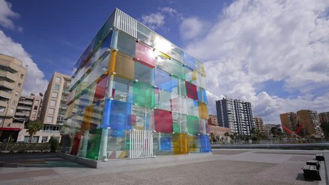 MALAGA, SPAIN - MARCH 22, 2016: Cube of the Centre Pompidou museum. Photo time-lapse, ultra wide-angle. The Pompidou museum is the local branch of the original in Paris and a popular tourist visit.