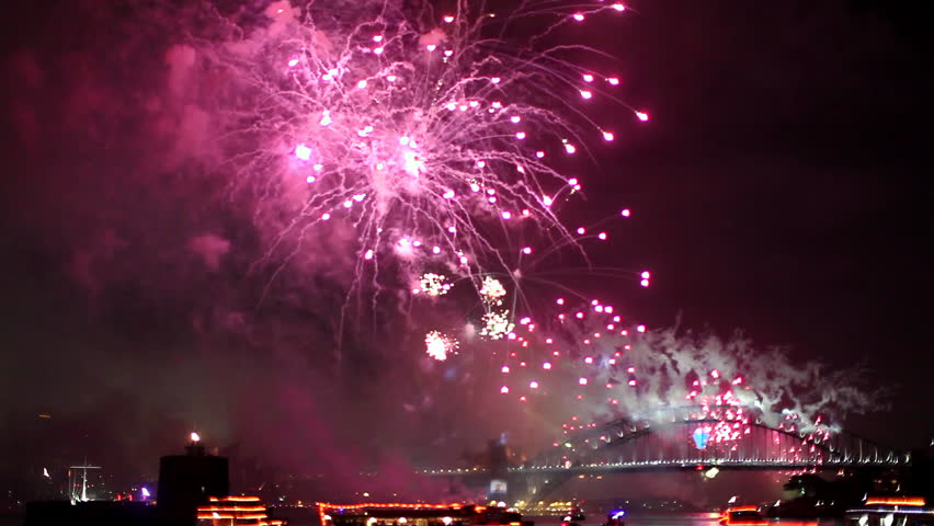 Green, Red and Pink midnight fireworks in Sydney to celebrate the new year 2015, from a boat.  Harbour Bridge on background