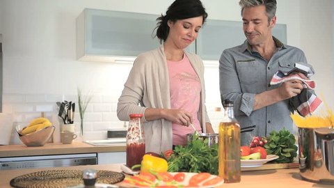 Middle-aged couple having fun cooking together