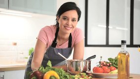Portrait of beautiful woman cooking in home kitchen