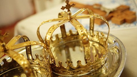 Close up of two gold wedding crowns prepared for ceremony  of marriage in a  church.