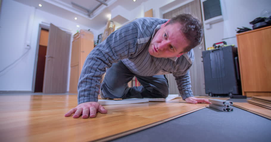 A man is checking if the wood panels that he's laying are even. He is every happy with his work and he shows thumbs up. Close-up shot. | Shutterstock HD Video #15423091