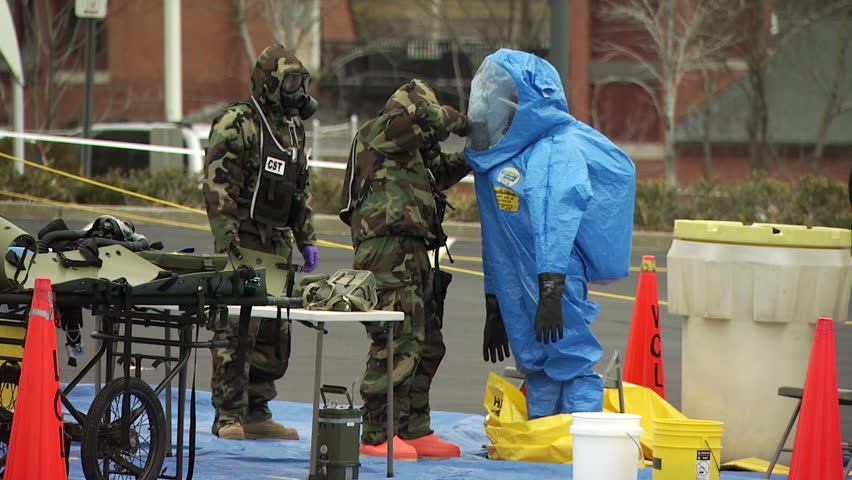 Zipping a HAZMAT team member into a protective suit  during a nuclear or biological disaster preparedness drill. Royalty-Free Stock Footage #15431572