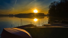Sunrise over lake shore with fisherman's boats 4k timelapse. 4096x2304