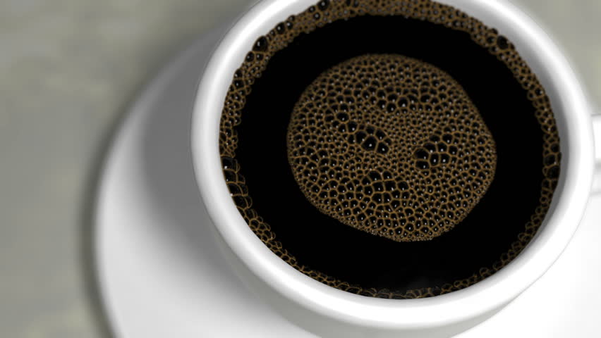 White coffee cup with black coffee.  The bubbles slowly pop to reveal an Alien (grey) face.