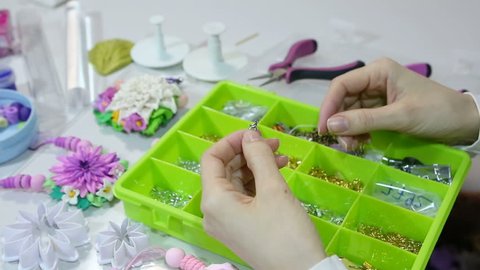 Accessories for needlework in container and tools for creating fashion jewelry in the manufacturing process. Jeweler making jewelry (bijouterie).Workshop. Hobby Bijouterie Modeling. 