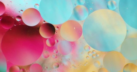 Color drops floating in oil and water over a colorful underground with oil painting effect. 