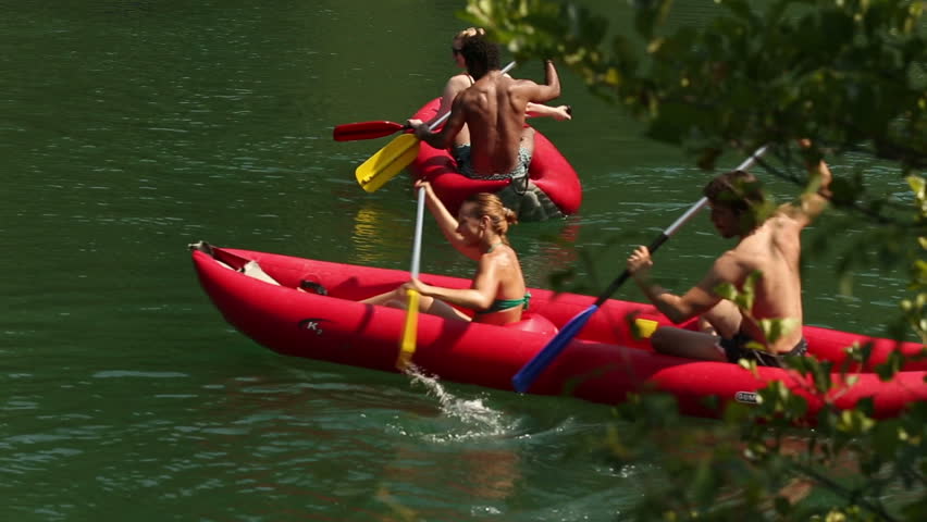 Group of four young adults having fun riding canoe on beautiful Mreznica river