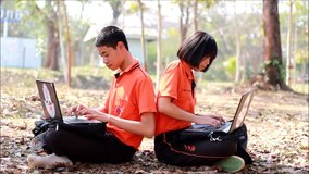 Students sitting and learning computer laptop on lawn in high school at LOEI Province, THAILAND.