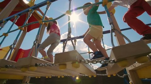 Low angle view of kids walking on playset in slow motion
