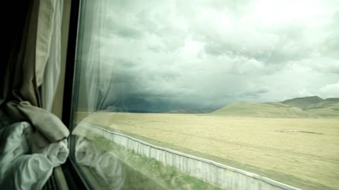 View from the window of the Qinghai-Tibet Railway. Virgin landscape with mountains in the background.