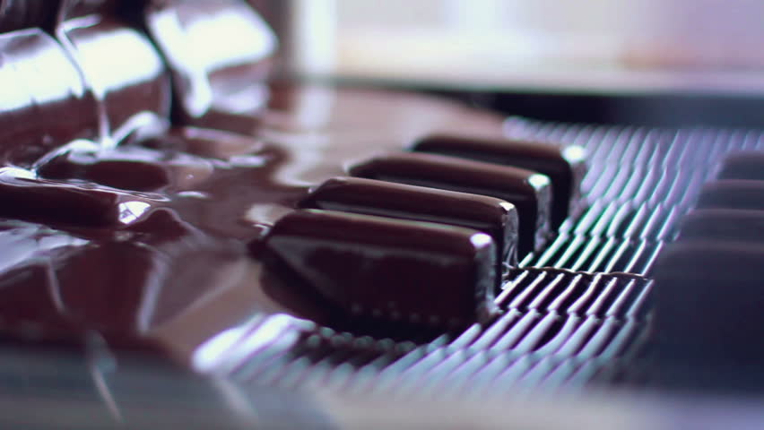 Production of chocolates/Candy poured by chocolate on production line/Desserts on conveyor belt at chocolate factory/Manufacturing process at food factory/Manufacturing line at food processing plant Royalty-Free Stock Footage #15455734