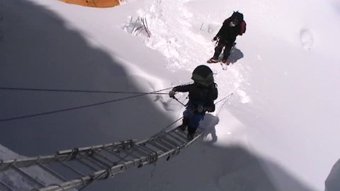 Climber climbs up ladder circa 2005 in Tibet.