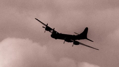 Grainy newsreel footage of B-29 Superfortress 'Enola Gay' flying during atomic bombing mission on Hiroshima, Japan in World War II. Slow-motion.  (dramatization)