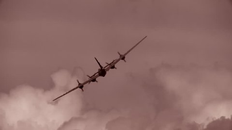 B-29 Superfortress 'Enola Gay' flying past dramatic clouds during atomic bombing mission on Hiroshima, Japan in World War II.  Slow-motion.  (dramatization)
