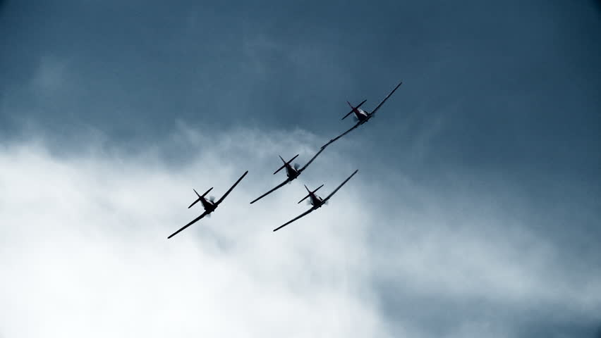 Four airplanes flying in formation away from camera in slow motion.