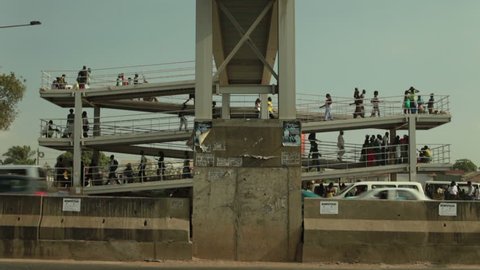 Luanda, Angola - 2002 - Shot of people walking up and down a spiral ramp leading to a pedestrian bridge.