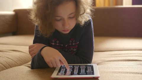 Little cute girl looking photos and playing computer games on the tablet. Entertainment, leisure and education of children with the help of modern technologies. Mobile apps for kids. Stock Video