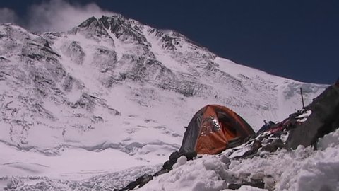 An expedition tent with Mt. Everest pinnacles and the summit in the background