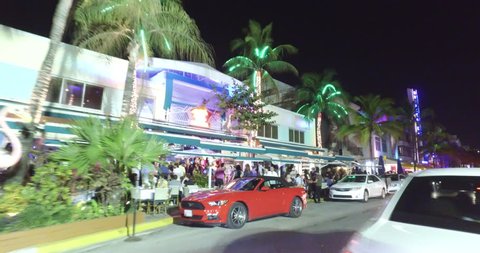 MIAMI BEACH - MARCH 22: Night motion video of Miami Beach Ocean Drive during 2016 Spring Break shot with a dji osmo on a segway March 22, 2016 in Miami Beach FL, USA