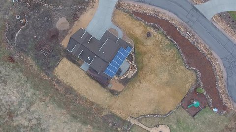 A high aerial shot of a house with solar panels and a large yard and property