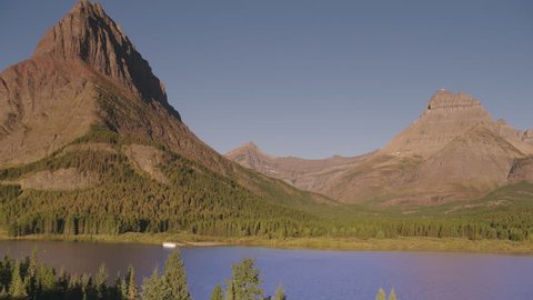 Swiftcurrent Lake with tour boat and Mount Wilbur, Many Glacier, Montana, America. 4K.