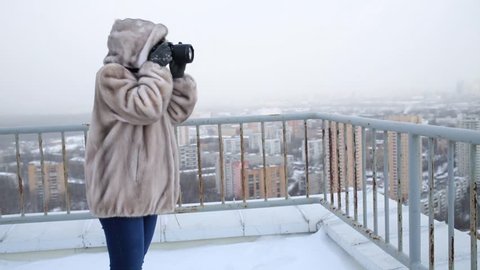 Woman in fur coat photographed panorama roof in winter.