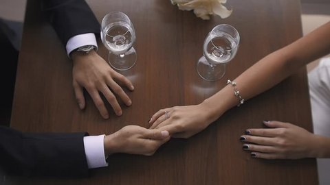 Closeup Toned of Bride and Groom Holding Hands at Restaurant