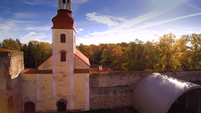 Long tower on the gate of the Poltsamaa castle. The red tower is found in the gate fronting the tall trees in the forest