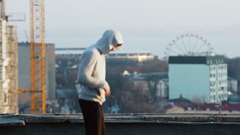 Young man doing exercise on the roof in the morning