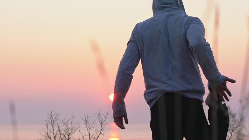 Young man doing exercise at the coast of the sea in the morning