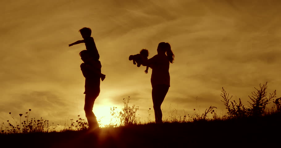 Happy family fun and hugs silhouetted dawn with orange sky | Shutterstock HD Video #15532438