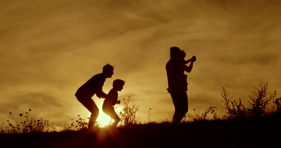 Happy family fun silhouetted dawn with orange sky | Shutterstock HD Video #15532492