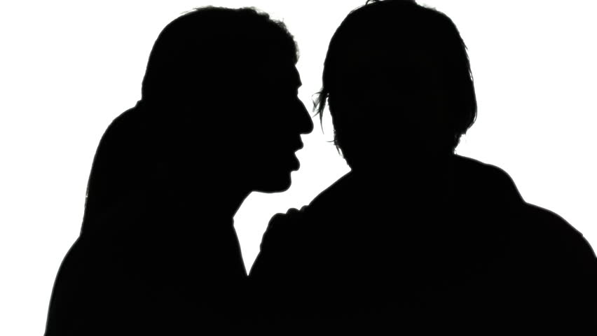A woman whispering a secret in the ear of a man. Silhouette shot.
 | Shutterstock HD Video #15537994