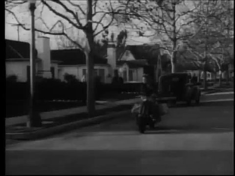 Paperboy on scooter delivering newspapers,1950s