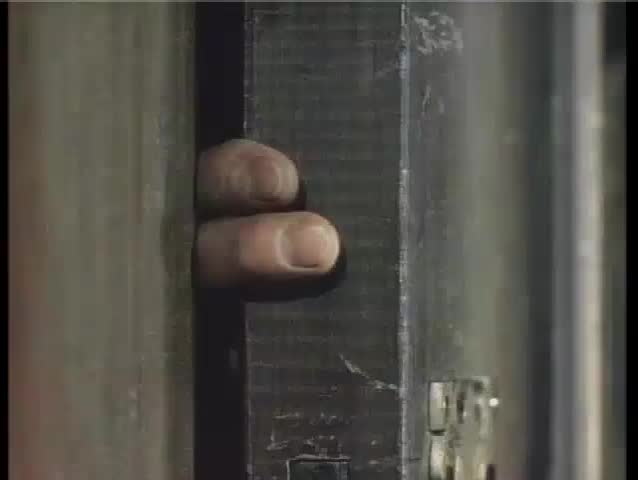 Close-up of fingers stuck in wooden door, 1940s