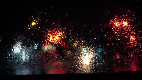 Slow Motion Rainy Dark Night view of the Wipers Motion From Inside a Car at a Red Traffic Light
