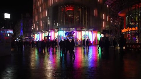 LONDON, ENGLAND - MARCH 29, 2016: A view of the iconic M&M store in Leicester Square after the latest storm in London, causing the ground to reflect the light of the store.