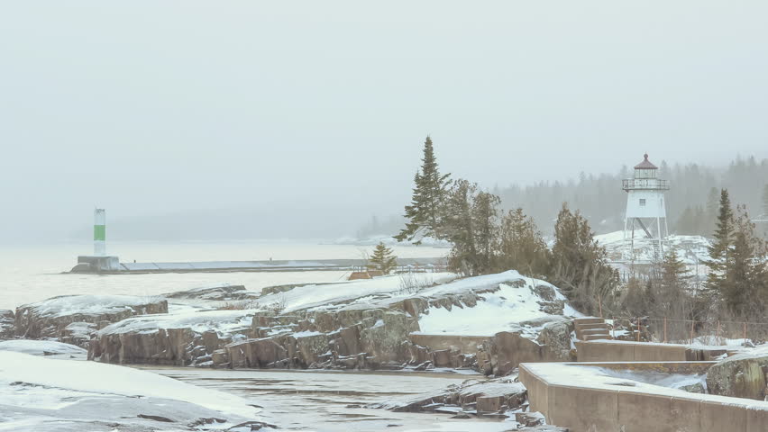 A Dark Winter Blue Hour Snowing Sunset at an Isolated Lake Superior Lighthouse in Grand Marais, Minnesota 4K UHD Ultra HD Timelapse