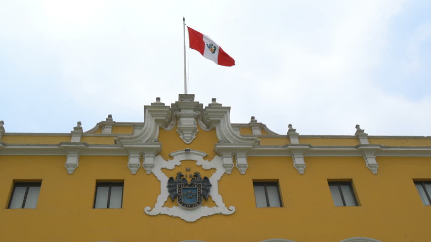 Peru flag waving on the yellow building in Lima, Peru