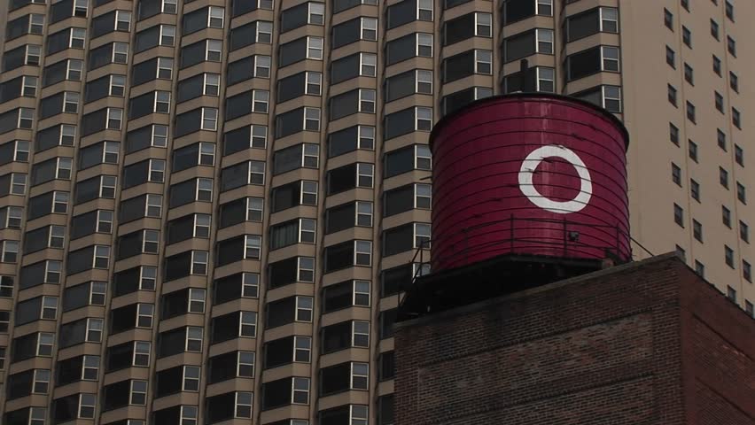 Old-fashioned water tower in foreground, high-rise condo in background