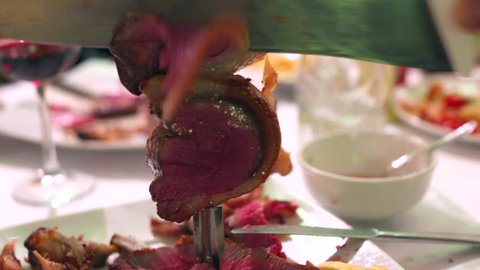Closeup of a Picanha roast beef cut in Brazilian Steakhouse Restaurant with sword