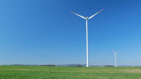 Wind turbine farm, alternative energy on green field. Sustainable energy sources concept.